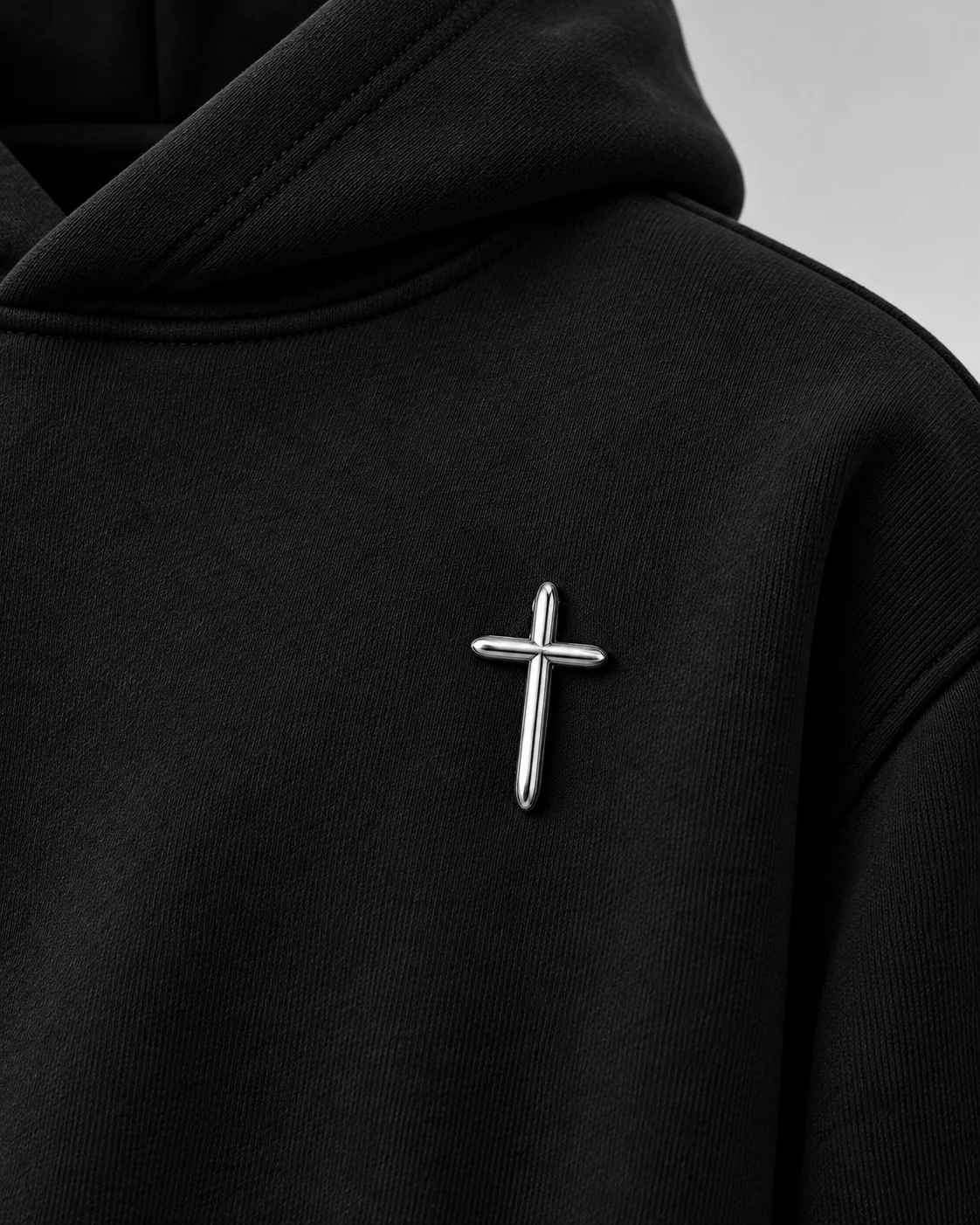 Close-up of reflective raised silver cross on black fabric